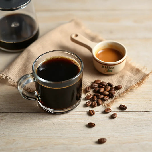 Cup of freshly brewed dark coffee with coffee beans and a wooden scoop on a wooden table