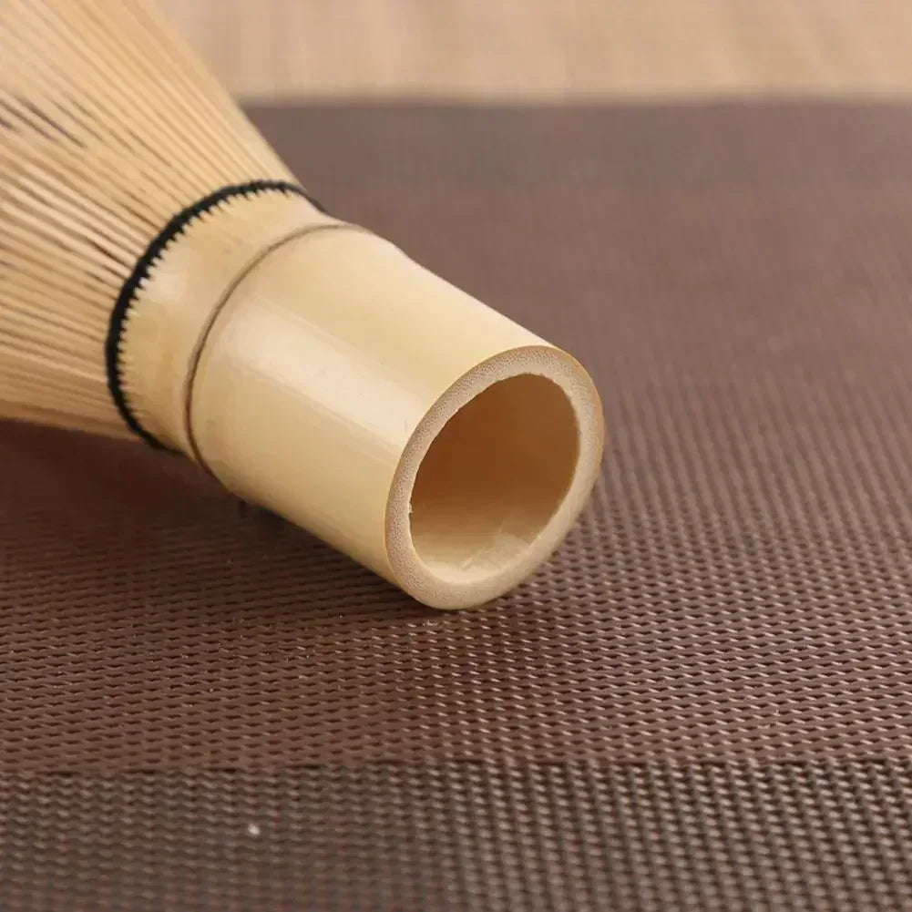 Japanese bamboo chasen whisk for matcha tea, with green tea powder, perfect for traditional tea preparation and tea accessories.